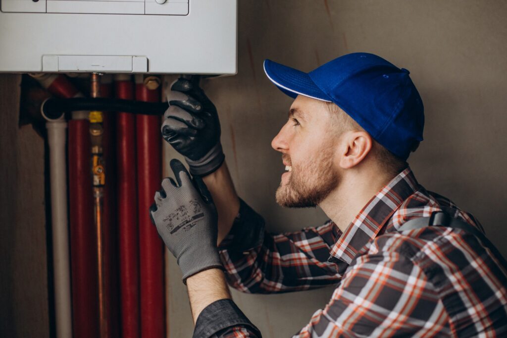 Service man adjusting a home heating and plumbing system.